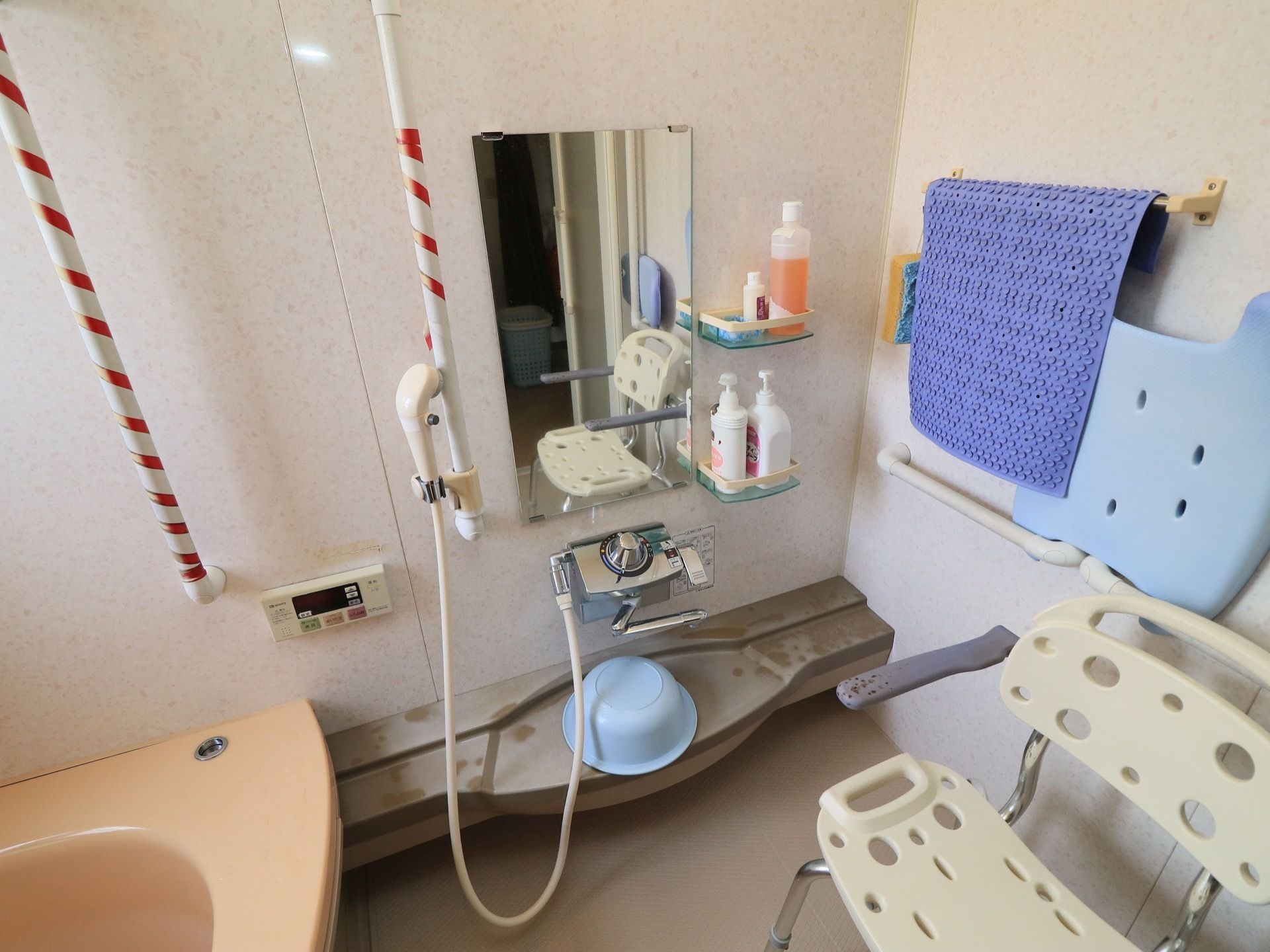 手すりが随所に設置されており、赤いテープが巻かれている。シャワーチェアや滑り止めマットが用意されている。