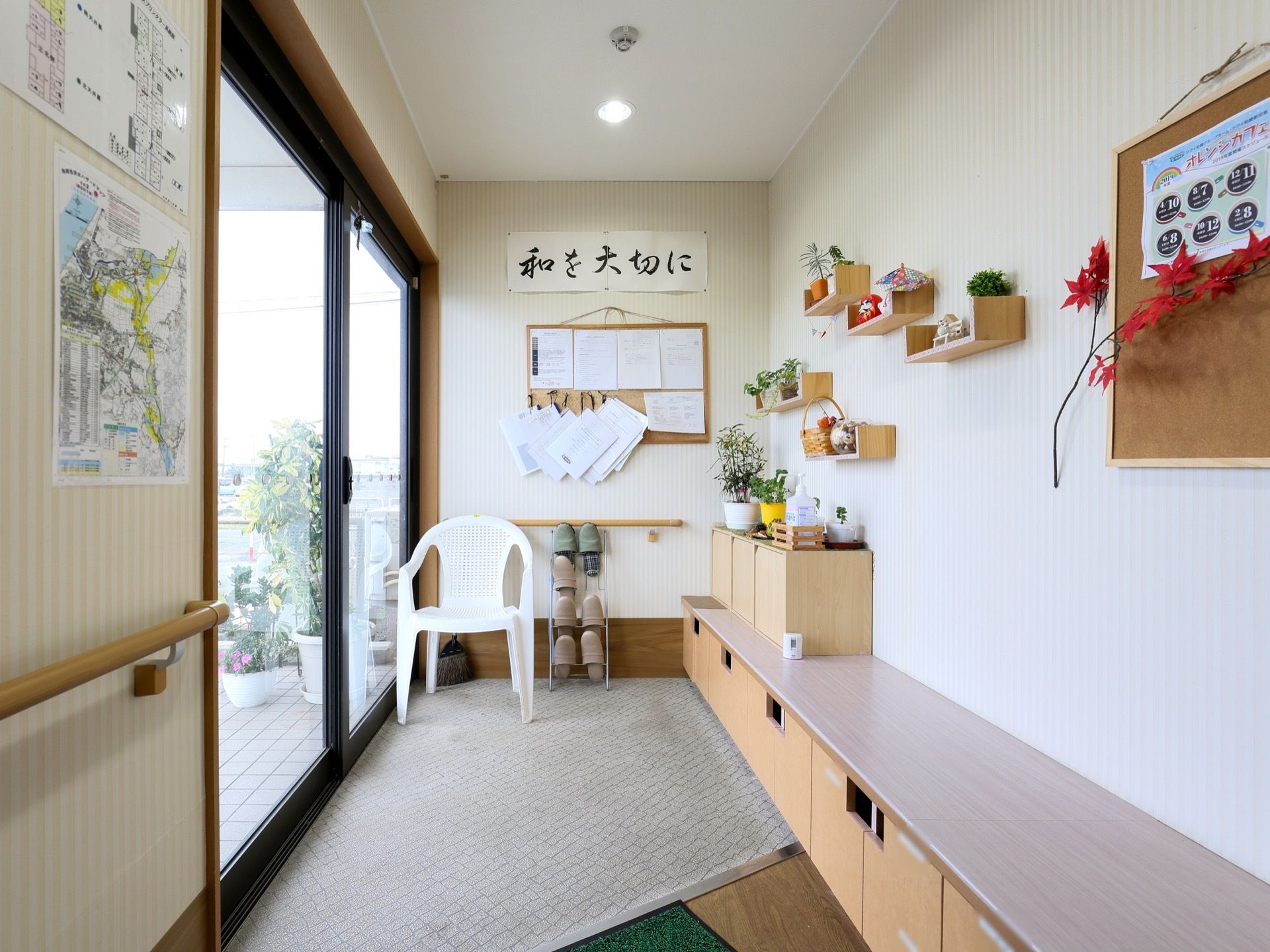 左奥に黒い枠の入り口扉が見えている。右手の壁際には低い位置に棚があり、ベンチとして利用できるようになっている。