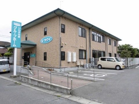 白地に緑の看板が通りに面して立てられている施設外観