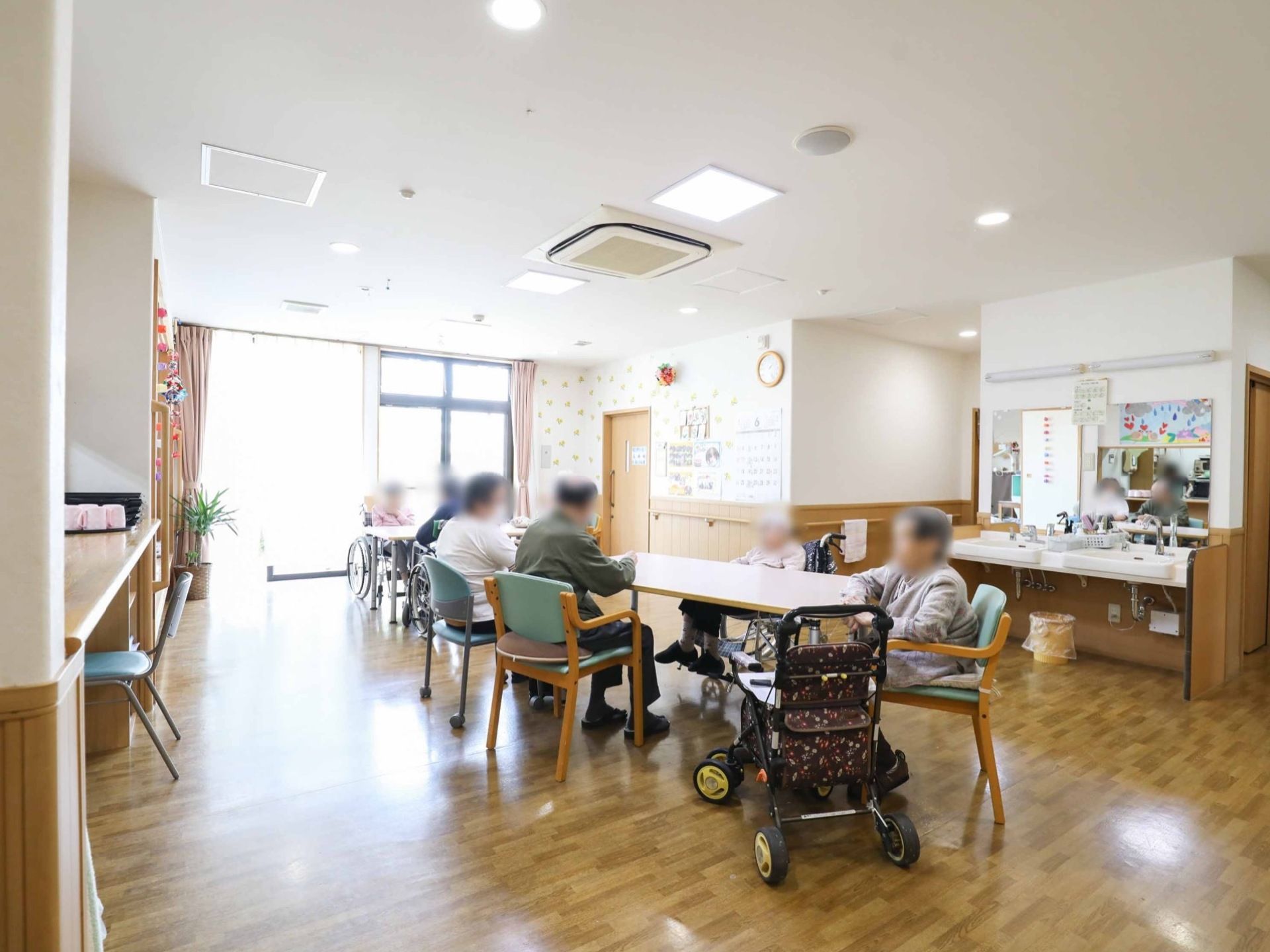 食堂は明るくゆったりとしていて、テーブルと椅子が置かれている。車椅子も利用しやすい洗面台と鏡が設置されている。