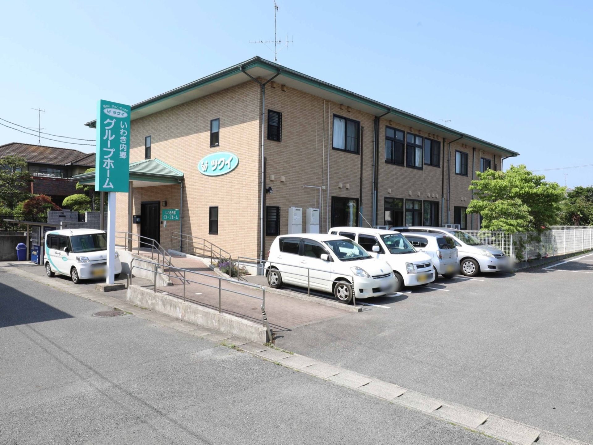 ブラウンの外壁の落ち着いた雰囲気の建物である。施設名の看板は緑色で、遠くからも良く見える。敷地は広く、大きな駐車場がある。