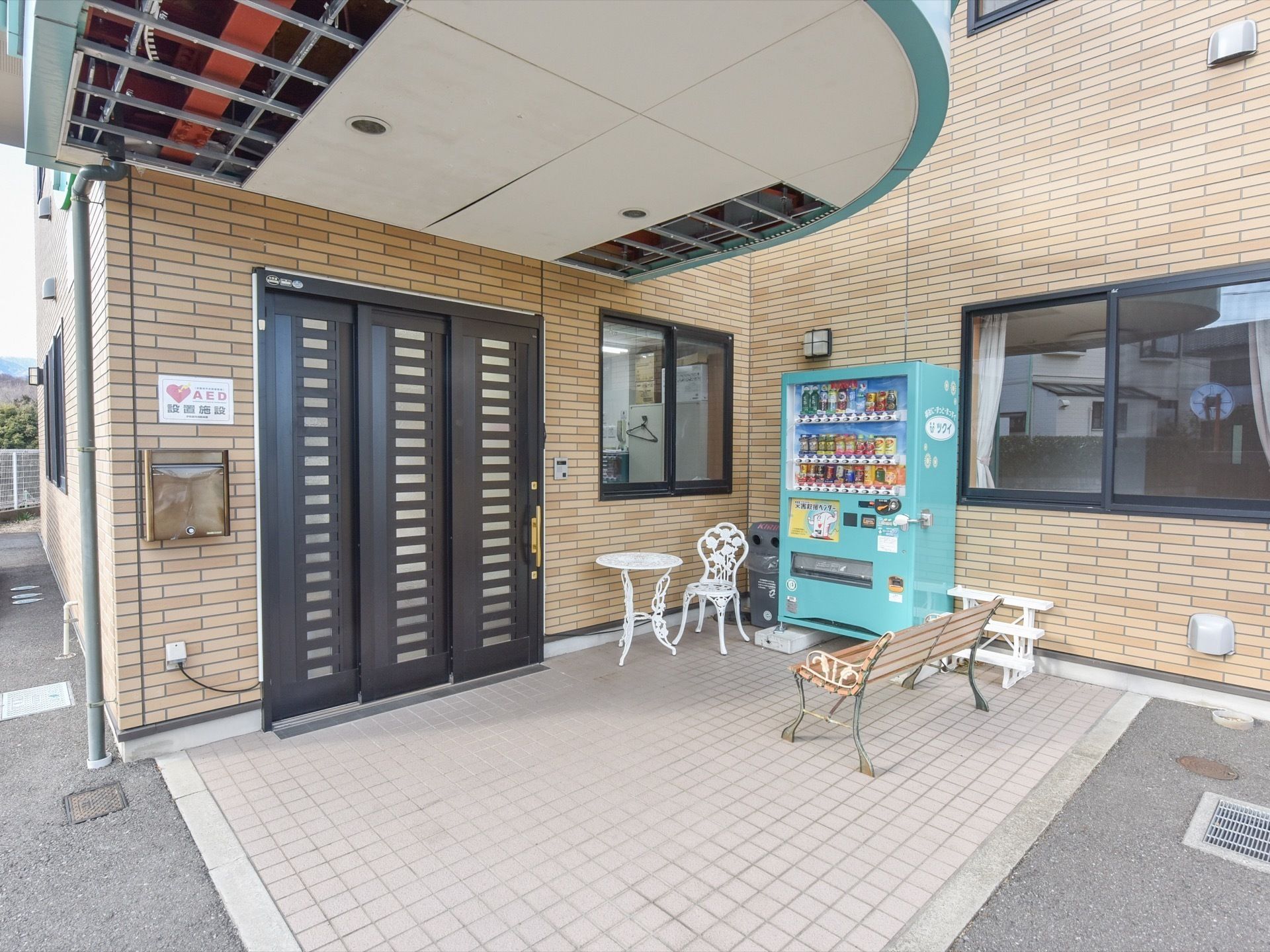 エントランスは、タイル敷きである。ベンチや自販機、椅子が置かれている。壁には、郵便受けやインターホンが設置されている。