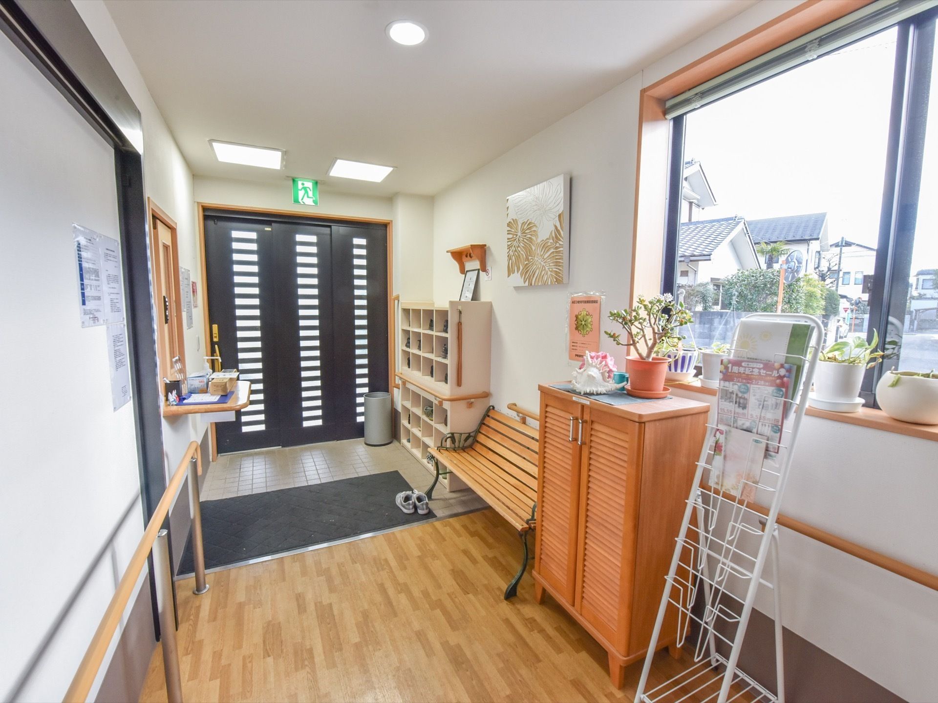 玄関ホールの壁際には、ベンチや靴箱が設置されている。左側には、受付が設けられている。マガジンラックや傘立てが置かれている。