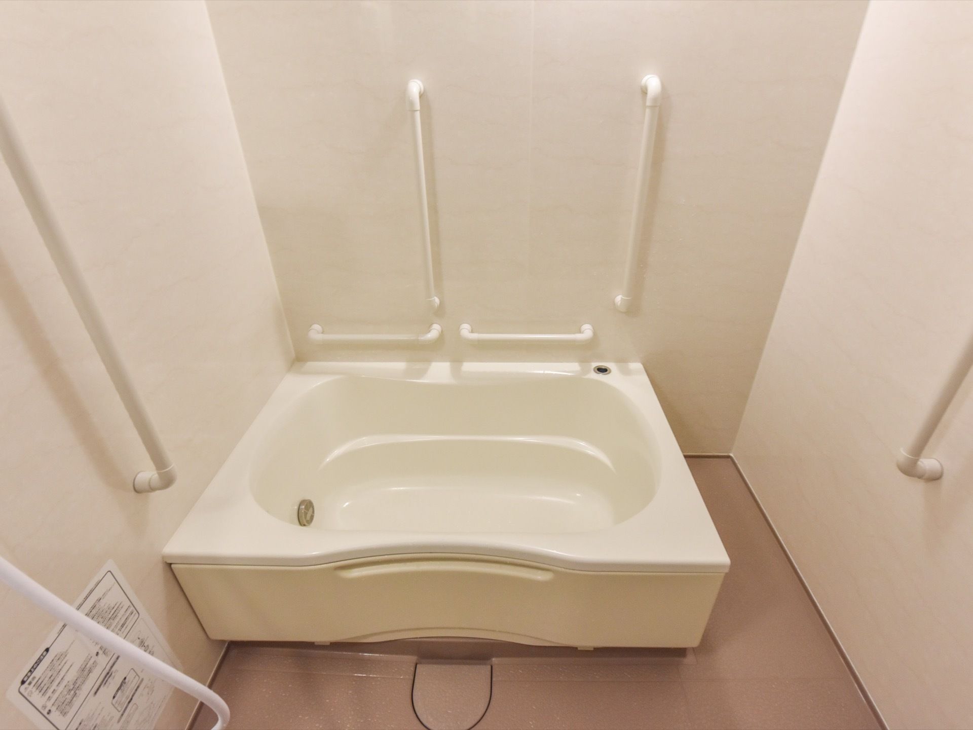 浴室には個浴用の浴槽が設置されており、シャワーが備わっている。複数の手すりが壁に取り付けられている。