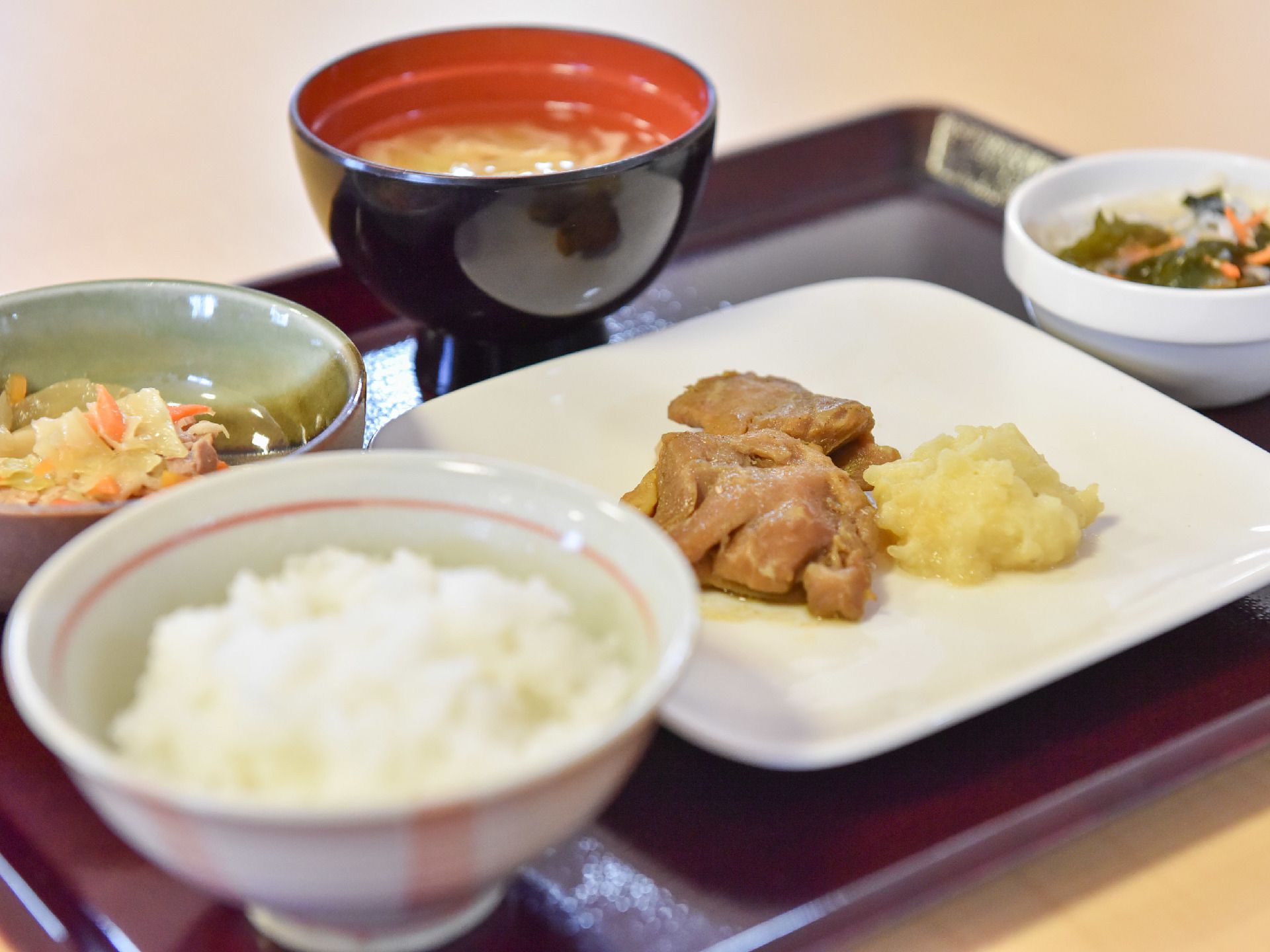 プレートに栄養バランスを考えられた食事がのっている。メインの他2品の小鉢がありご飯と味噌汁も提供されている。