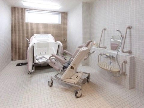 白く清潔感のあるタイル張りの浴室である。介護浴槽を完備しているので、楽な姿勢でさっぱりとしていただける。