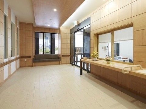 車椅子をご利用の方でも気持ちよく出入りが行えるように、広々としたスペースを設けたエントランスである。横側にはステンドグラスを取り入れている。