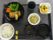 黒いお盆の上に、いくつかのお皿に盛りつけられた料理がある。料理はシンプルながらバランスの良い食事となっている。
