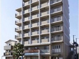 分譲マンションのような外観で白い壁面が美しい。併設されているクリニックと薬局の看板が入口にかかっている。