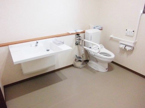 トイレは車椅子をご利用の方がスムーズに便座まで進めるように、広い空間である。便座周りには手すりが完備されており、座るときの支えとなる。