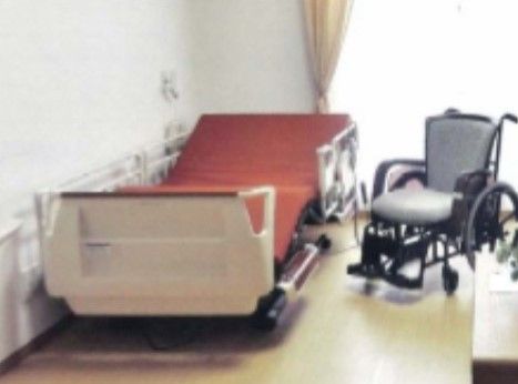 リクライニング機能がついたベッドと車椅子が置かれた部屋