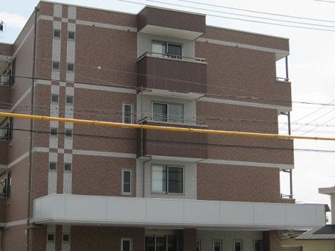 施設の外壁は薄茶色と白色のタイル貼りになっており、ツートンカラーでデザイン性のある落ち着いた外観になっている。