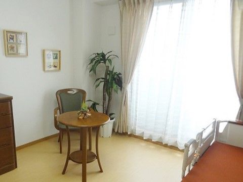 明るい掃出し窓のある居室である。入居者様は椅子に座りコーヒーなどを飲みながら寛ぎの時間を過ごすことができる。