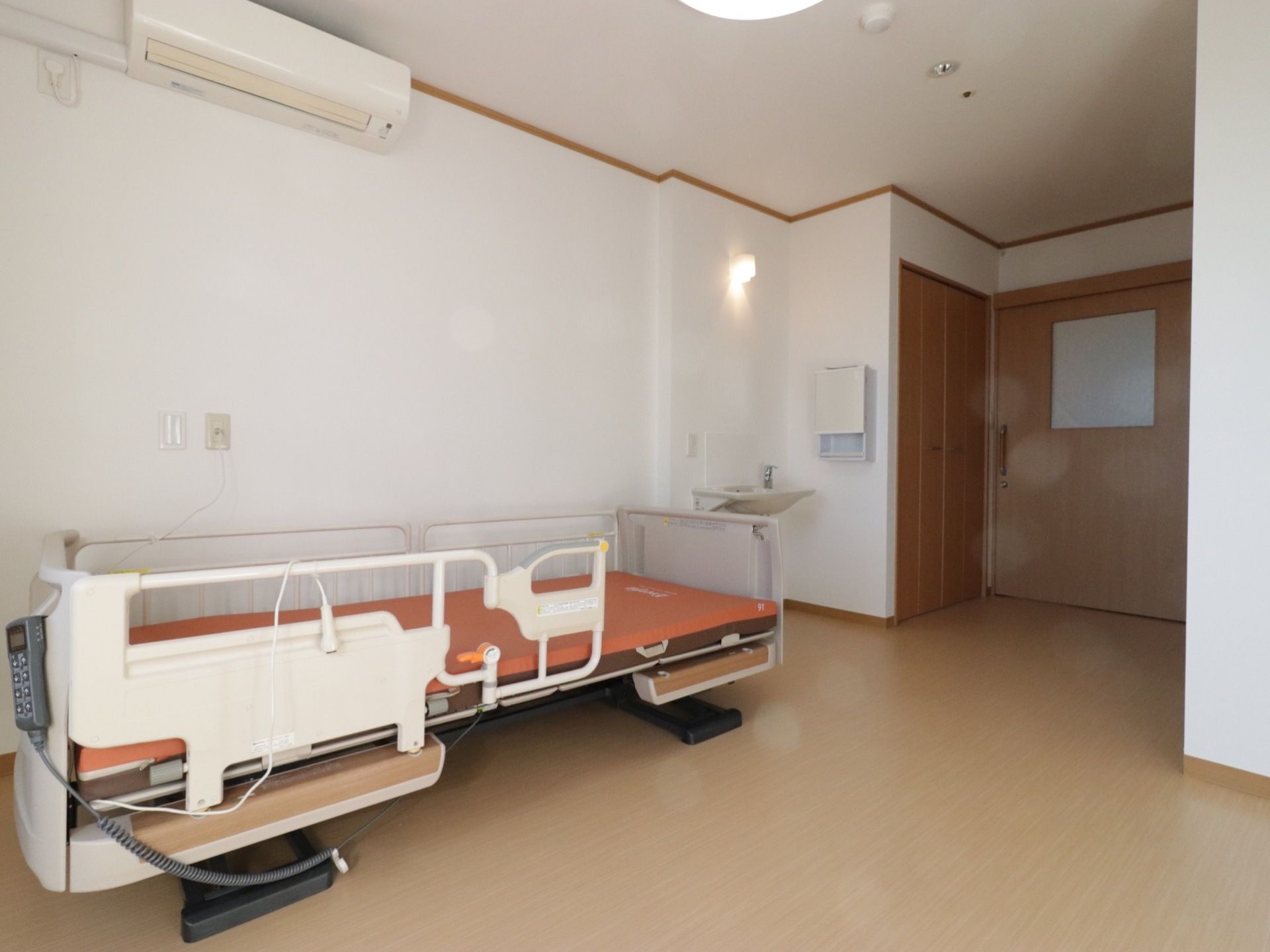 居室の扉は間口が広く、車椅子をご利用の方にもスムーズに出入りしていただける。床は移動しやすいフローリングである。