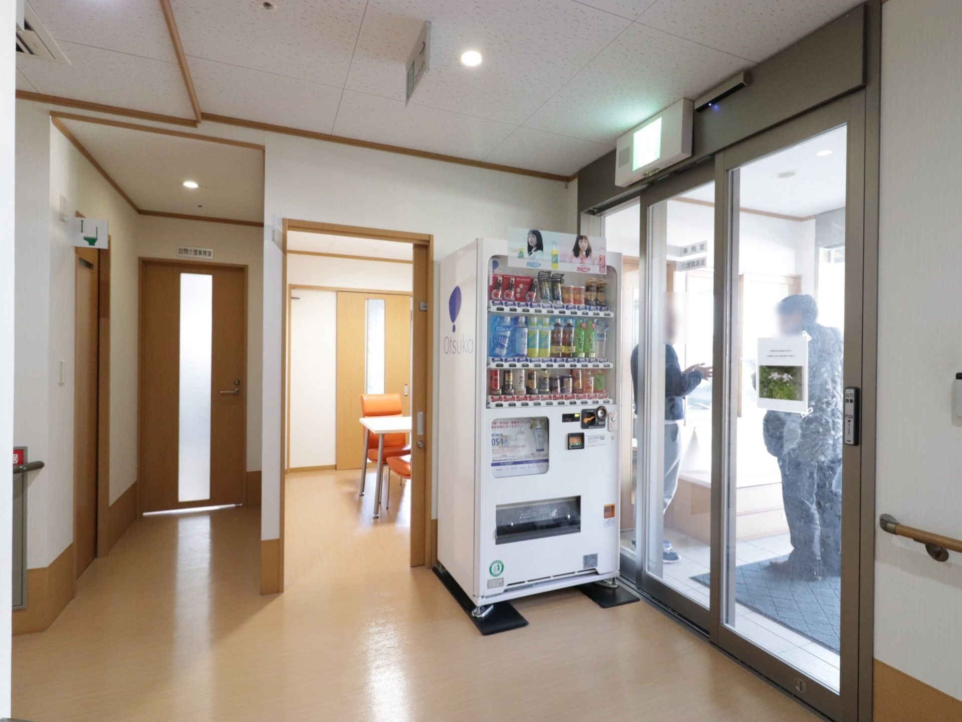 玄関には間口の広い自動ドアが設置されている。自動販売機が設けられている。床はフラットで移動しやすくなっている。