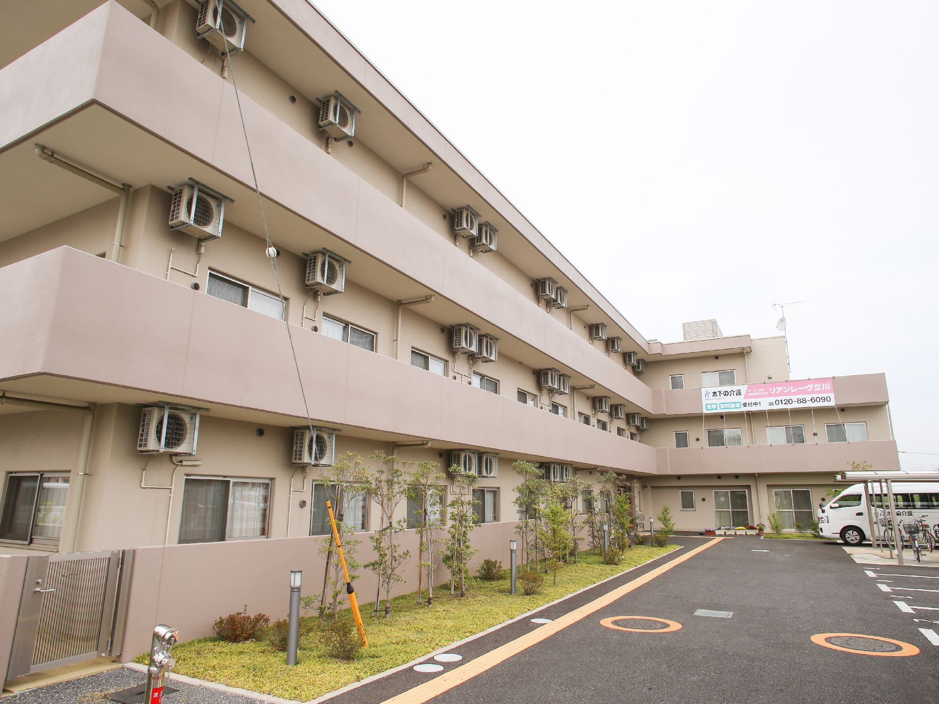 入居者募集の垂れ幕が下げられている、ピンク色の建物