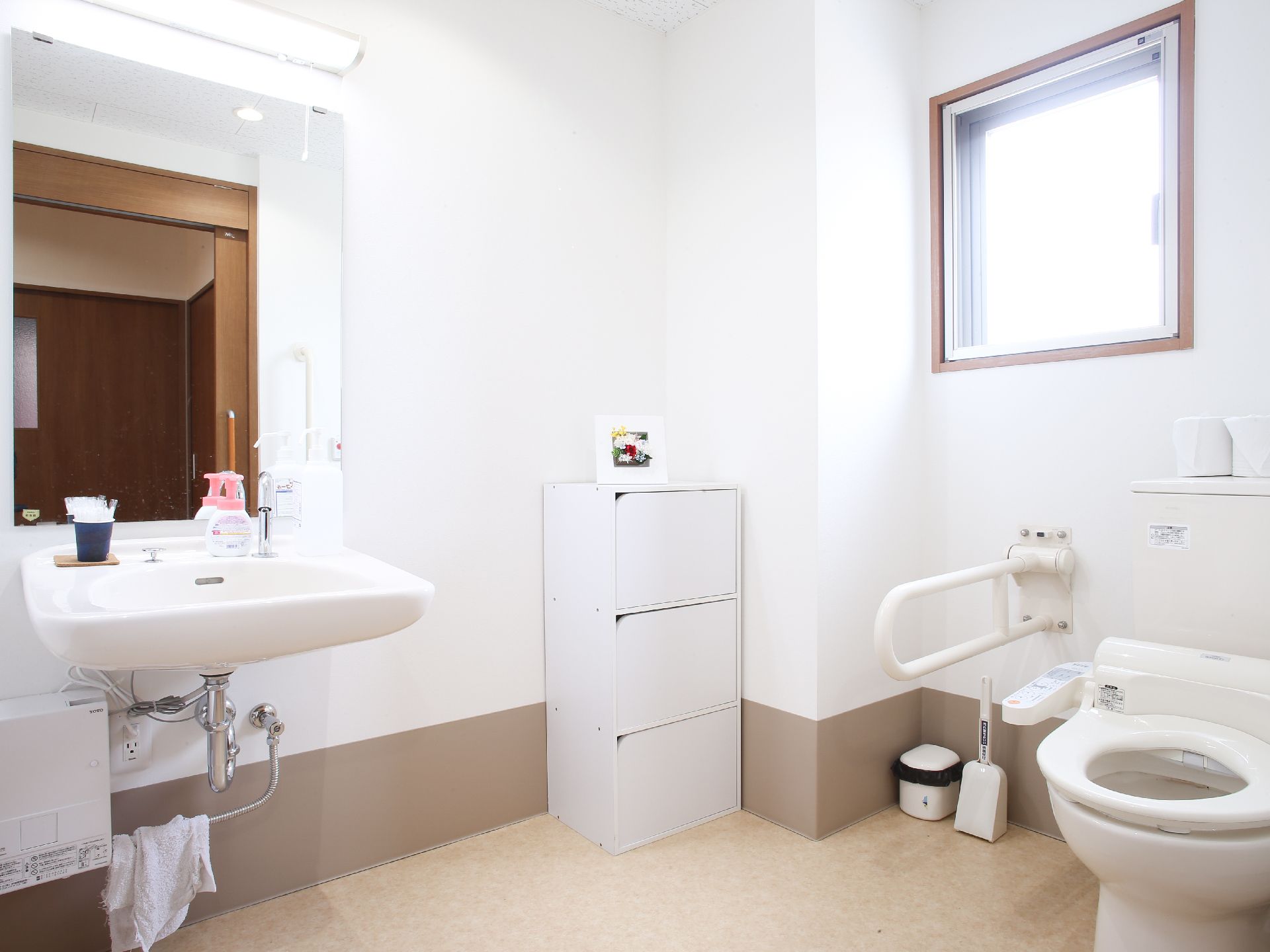 トイレは白を基調としており清潔感がある。シャワー付便座で、腰掛便器用の手すりが設置されている。鏡付の手洗い場がある。