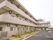 3階建の建物で、駐車場と駐輪場が付いている。駐車場と建物の間には植物が植えられている。消火栓が設置されている。