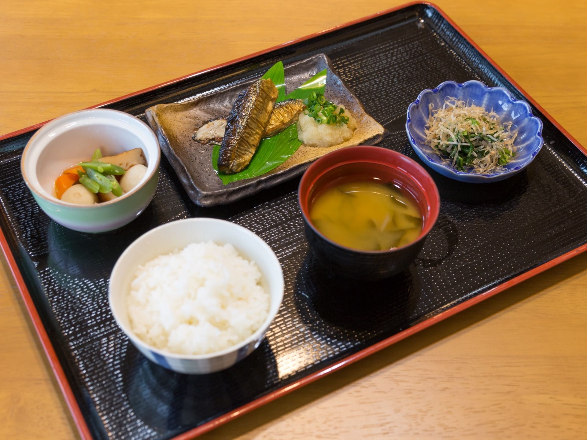 施設内で提供される、食事の一例。一汁三菜の食事で、メインのおかずは焼き魚である。野菜の煮物と野菜のおひたしもある。