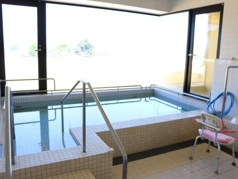 浴槽の奥にある大きな窓から外光が差し込んでいる大浴場
