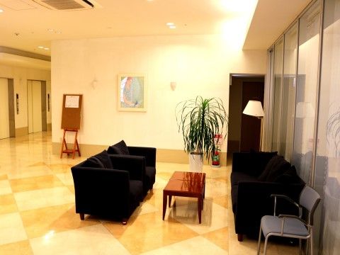 座り心地の良さそうな黒いソファーと小さなテーブルが並べられている。床にはお洒落な模様が描かれており、高級感がある空間となっている。