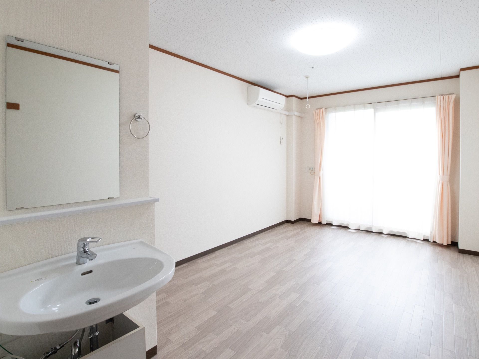 窓が大きく日当たりが良い。床はフローリングになっており、エアコンが設置されているので快適に生活ができる。