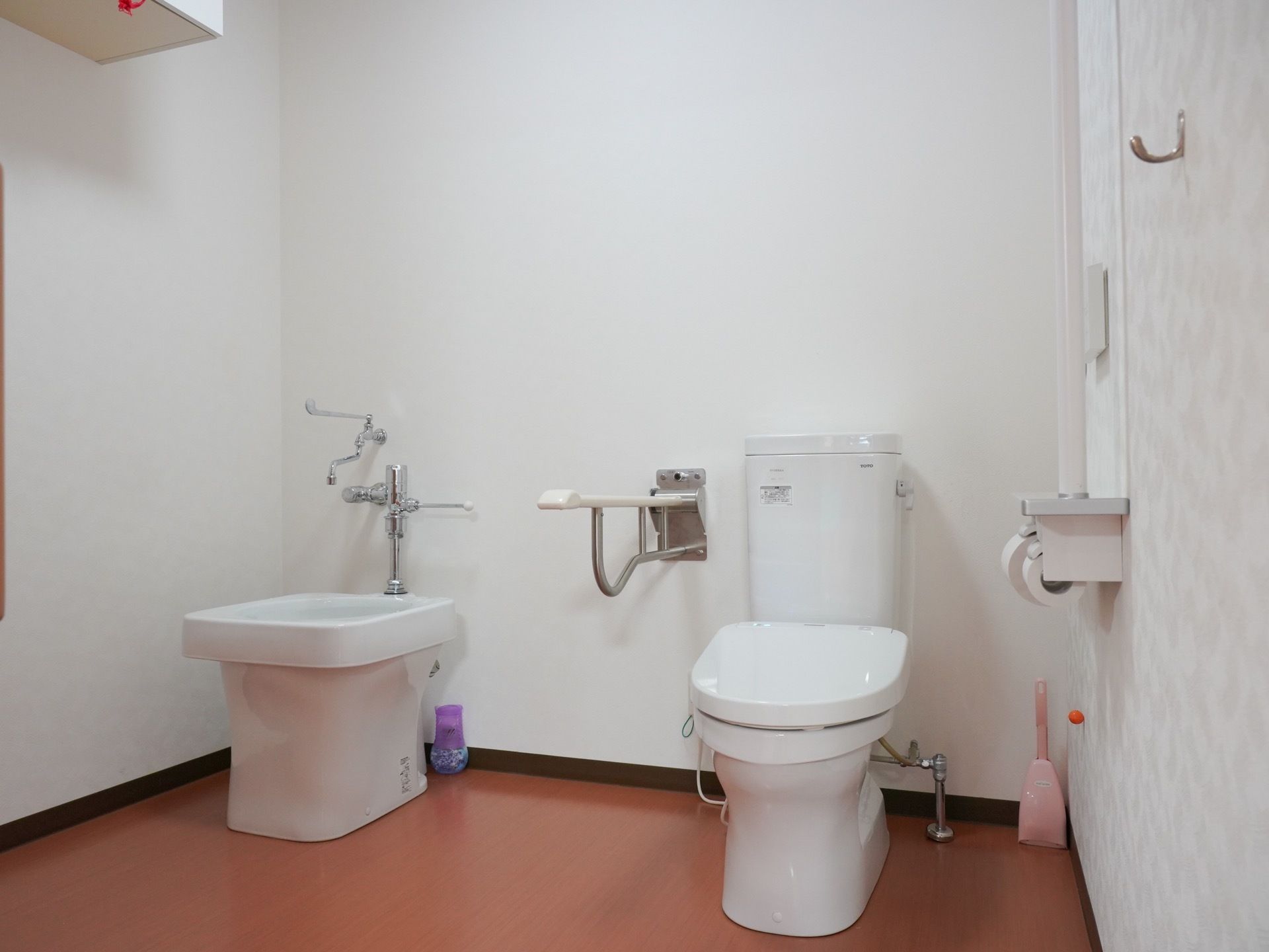 洋式便座が１台設置されており、左側の壁にトイレットペーパーホルダーやナースコールが備えつけられている。