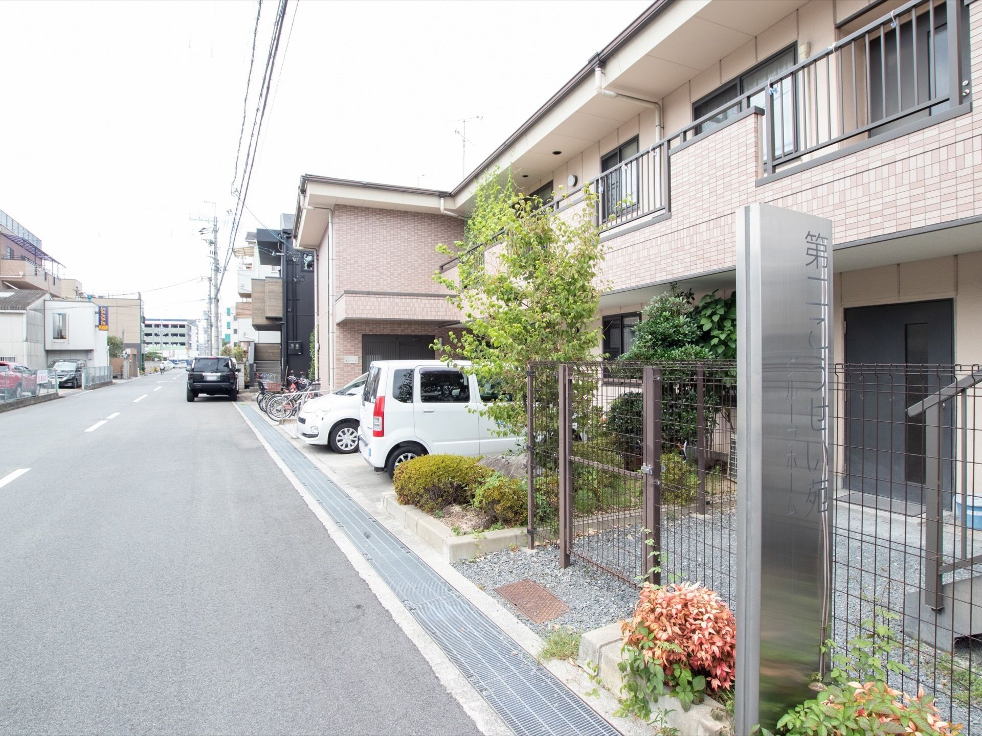 ブラウンのタイル張りになっている建物で、２階建てである。広い道路に面しており、駐車場が完備されている。