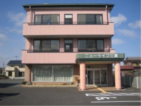 施設の建物は３階建てで、外壁にはベランダが設けられている。玄関には屋根が設置され、周囲はフラットな設計になっている。