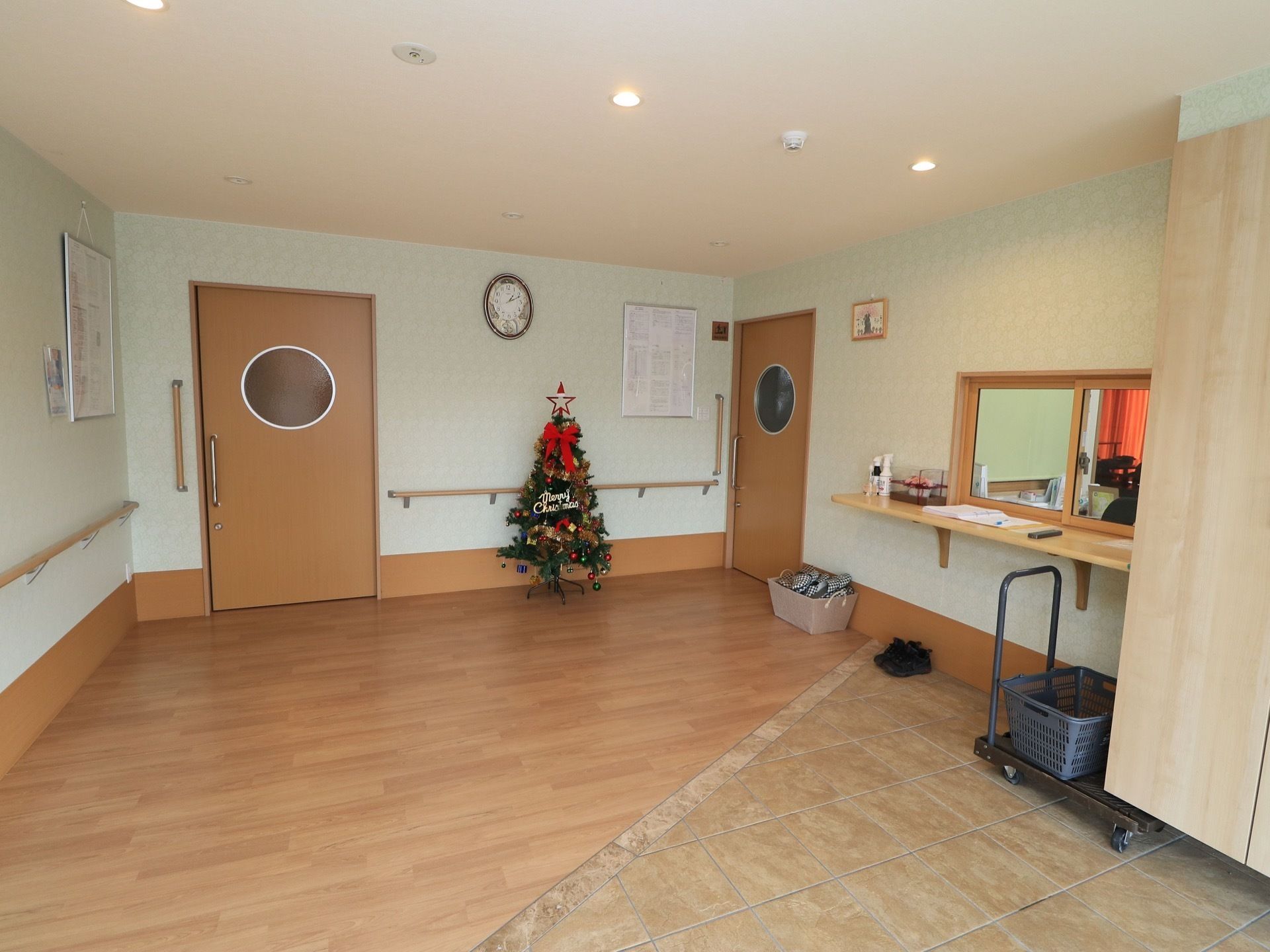 玄関は段差がなく、フラットになっている。箱の中にスリッパが収納されている。ホールにクリスマスツリーが飾られている。