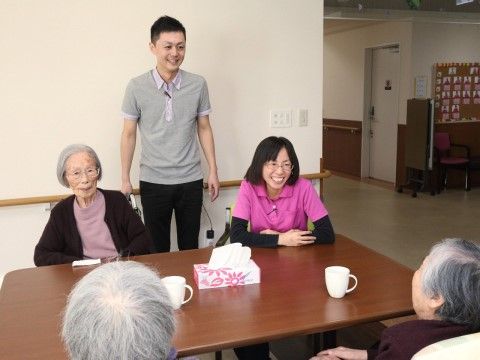 お茶を片手にテーブルの周囲に集まって会話を楽しむ入居者様