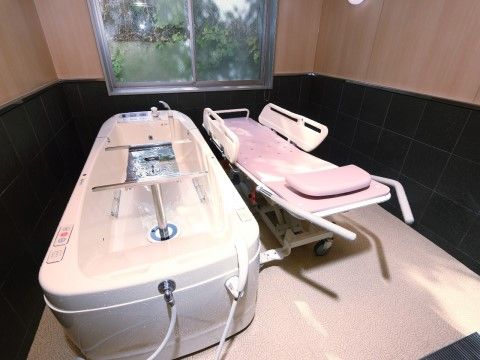 介護浴槽が置いてある浴室は、壁の下半分が黒色のタイル貼りとなっており、落ち着いた雰囲気を感じられる。