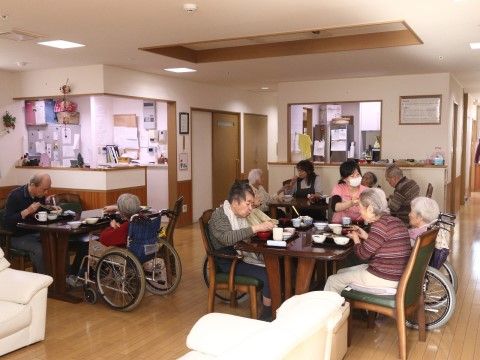 椅子や車椅子に乗って、ダイニングで食事を楽しんでいる入居者様