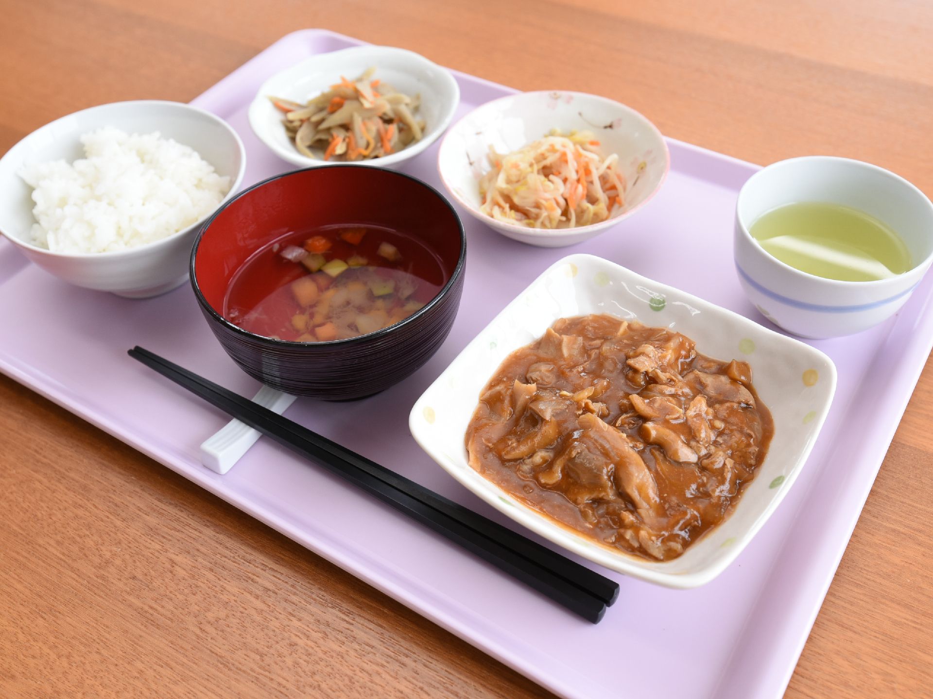 ご飯と汁物の他に、おかずが３品、お盆の上に並んでいる。お茶も用意されている。食べやすいように、具材が一口サイズにされている。