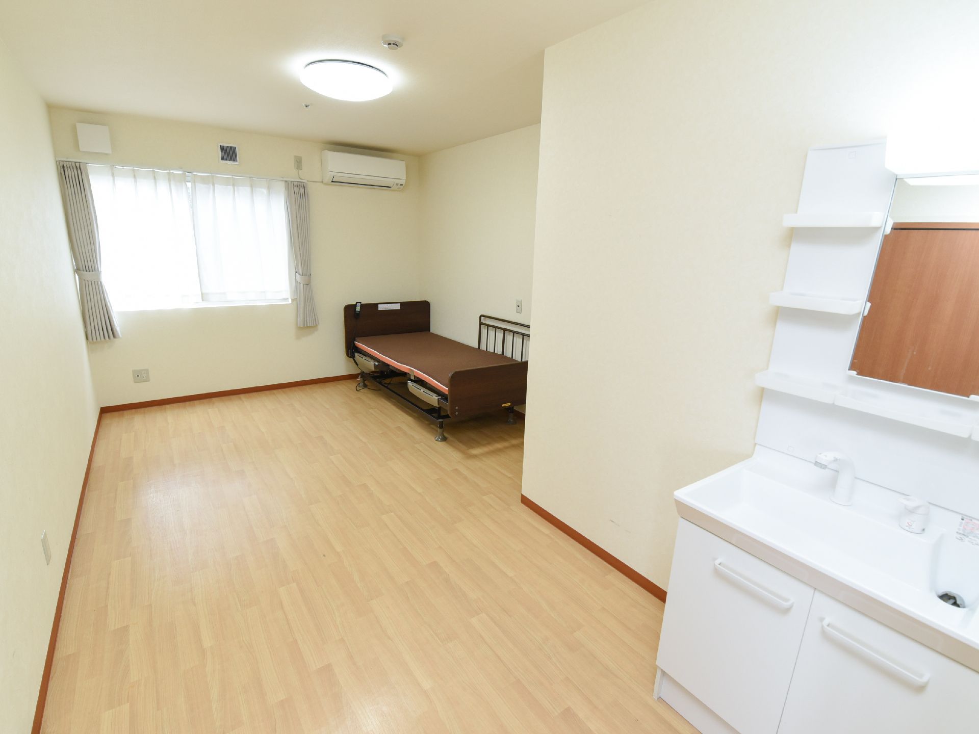 入口前に、大きな鏡の周りに小物置場がある洗面台が設置された部屋