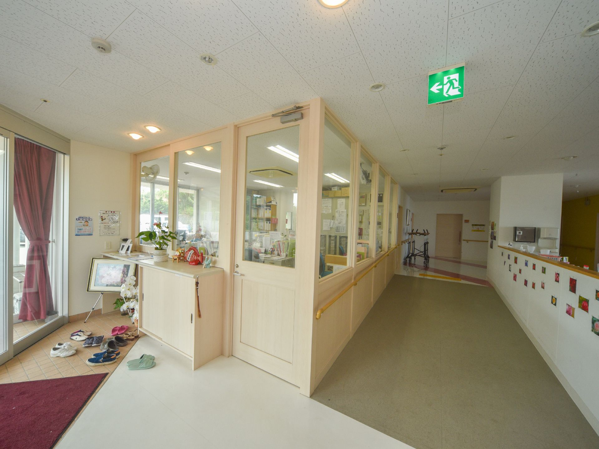 天井部分に非常口の看板がある通路部分は、右手の壁に小さな写真がたくさん飾られており、左手はスタッフルームのエリアとなっている。