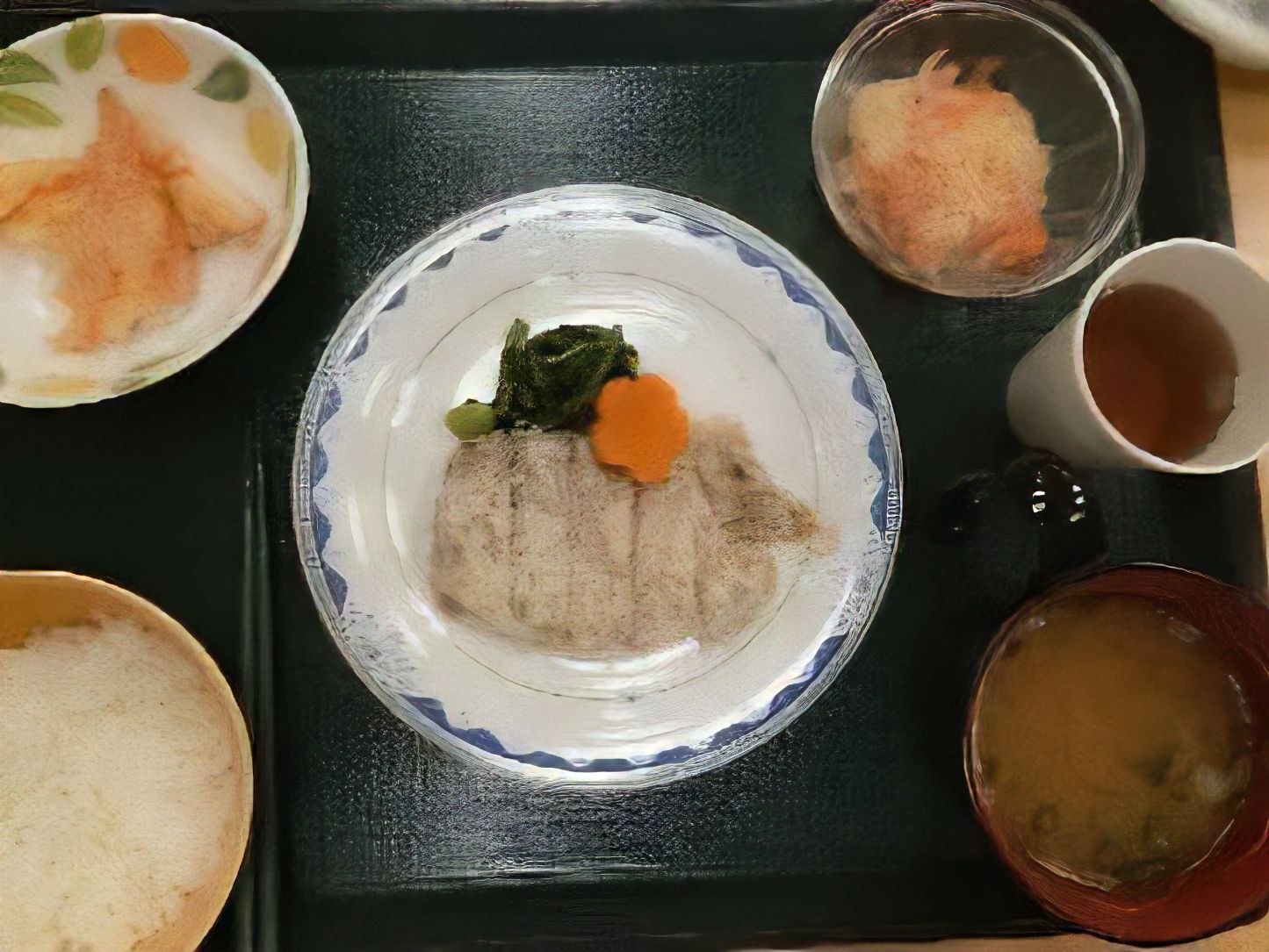 ステーキに天ぷらや酢の物、味噌汁がついた定食のトレイ