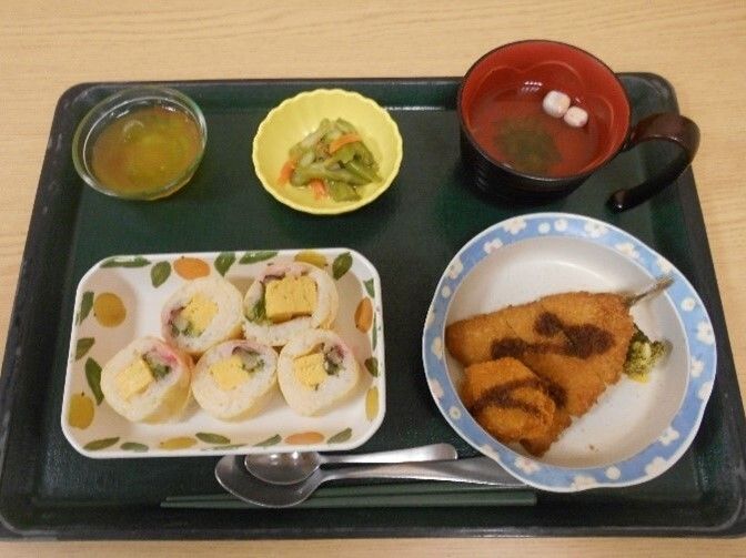 アジのフライやお吸い物。巻きずしがおかれ、小鉢が2つほどある