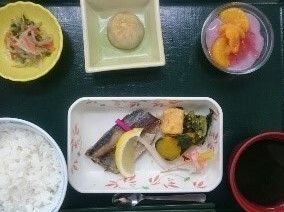 5品ほどの料理と白米が載った茶碗。それらが黒いお盆に乗ってる