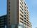 10階建てのマンションのような建物である。大きな看板が設置されており、目を引いている。ベランダが各階に備わっている。