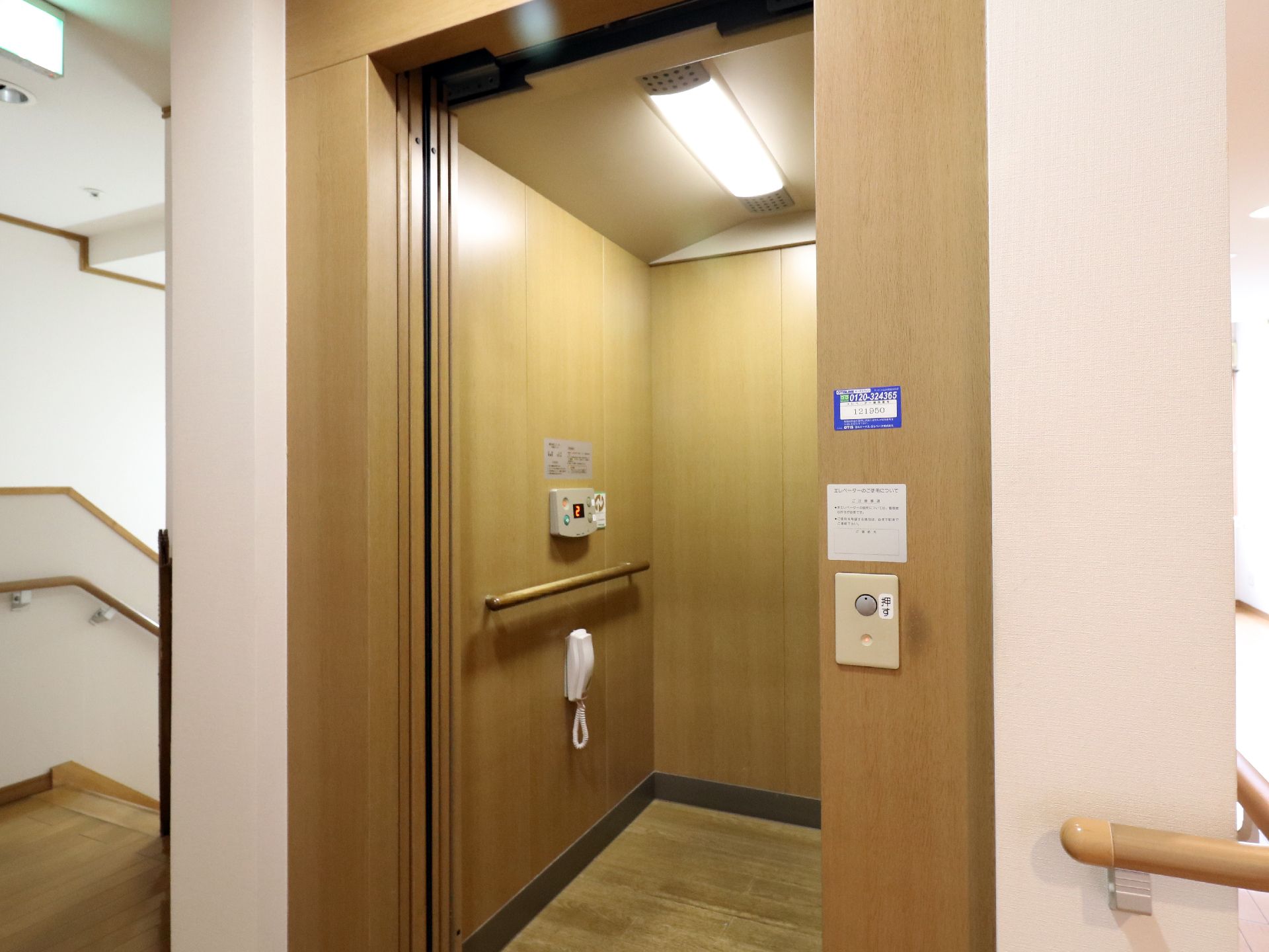 エレベーターの内部は木目調になっており手すりや電話が敷設されている。周りの壁には手すりが伸びている。