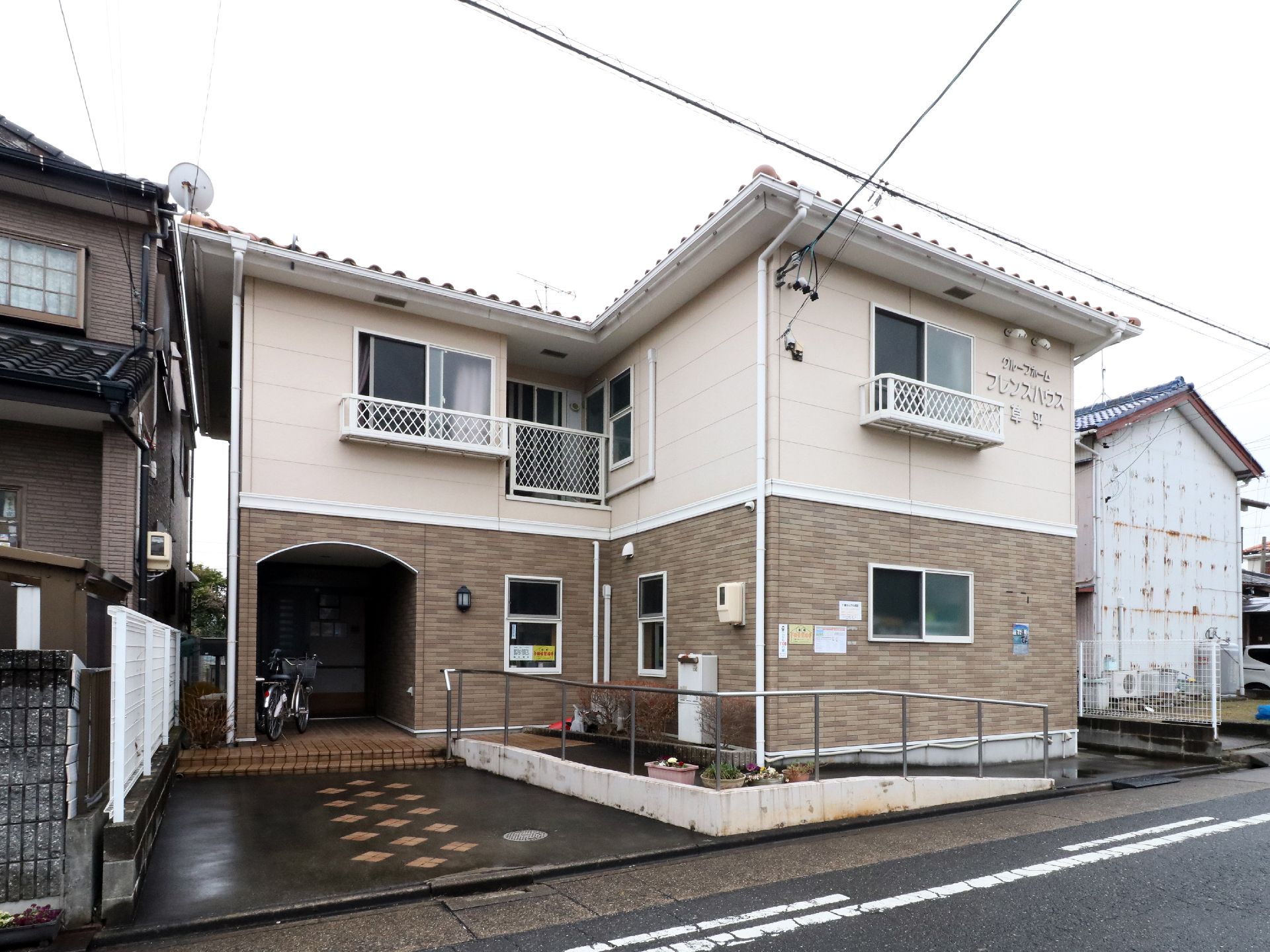 一軒家のような外観で、玄関前まで階段とスロープが続く建物