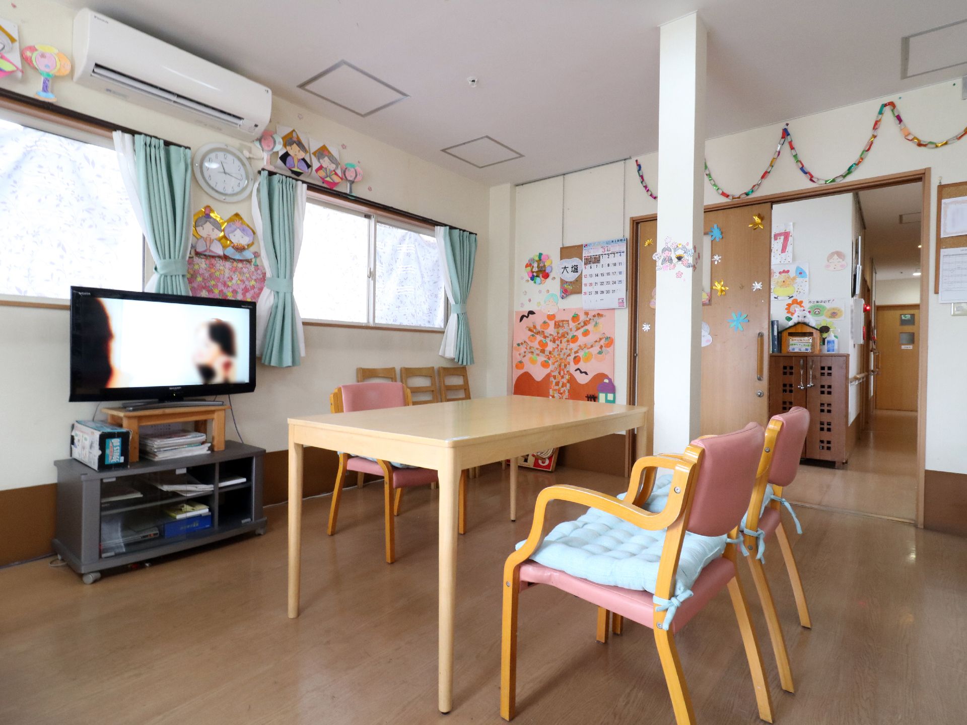 電源の入った大型液晶テレビに向かってテーブルが置かれているリビング