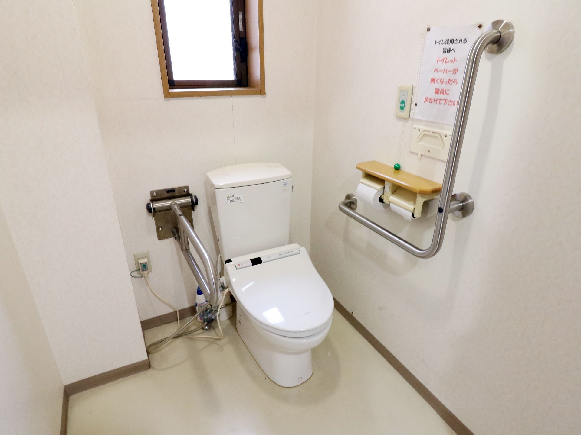 トイレの上には小さな窓がついている。右側の壁にはL字型の手すりがありトイレットペーパーや呼び出しベルがある。