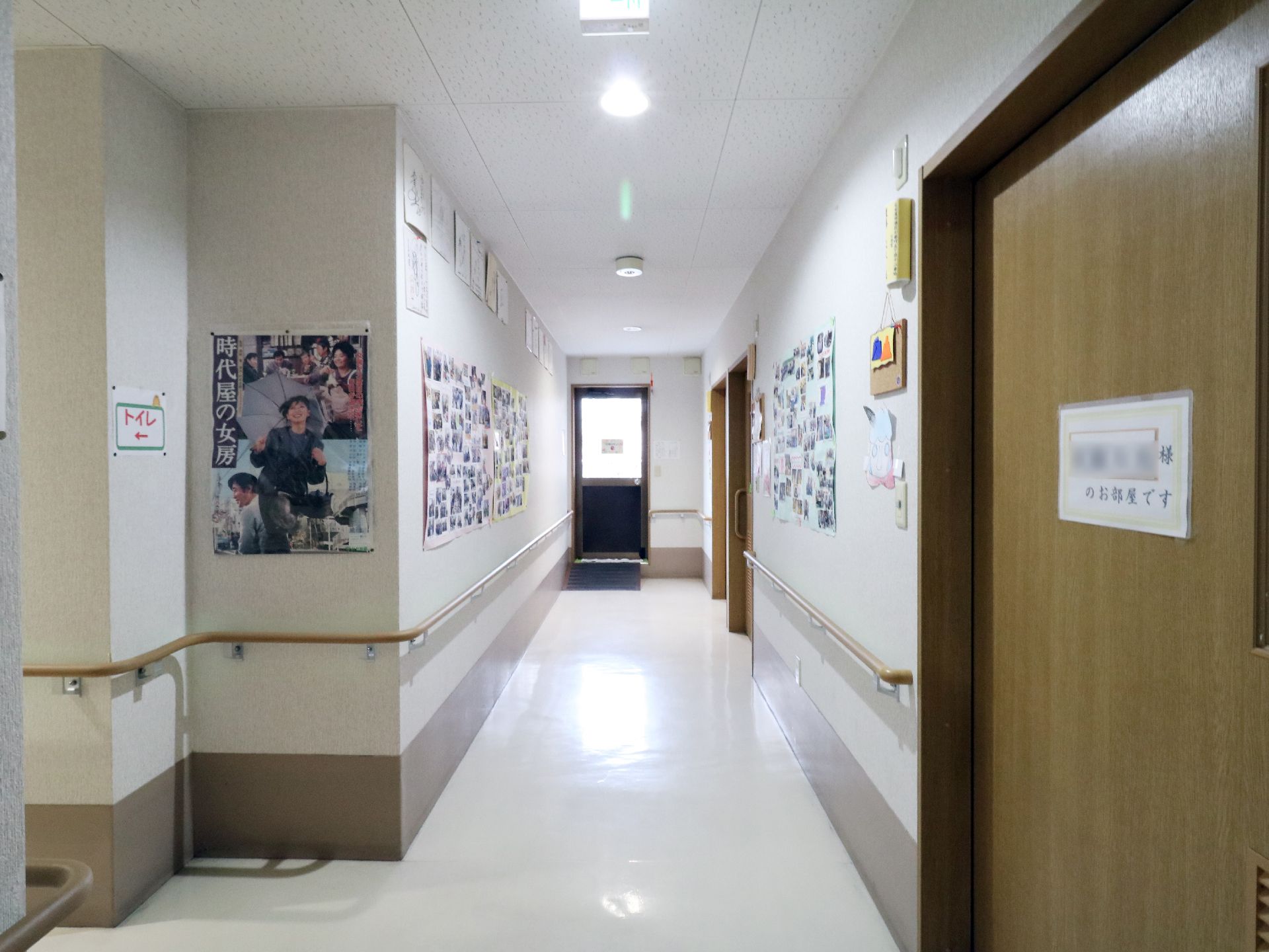 廊下の両側には手すりが敷設されており壁には多くの写真などが貼り出されている。右側手前は扉になっている。