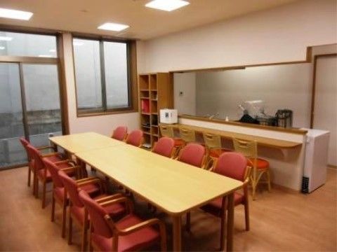 長く置かれたテーブルの周囲に赤い椅子が並べられているダイニング