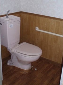 トイレの壁には横方向に手すりが設置されており、入居者様がトイレを使用する際には手すりを使い安全に座ることができる。