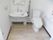 明るいトイレである。便器の左側には洗面台が設置されており、入居者様はトイレを使用後速やかに手を洗うことができる。