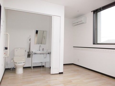 カーテンで仕切られている個室トイレが用意されている居室