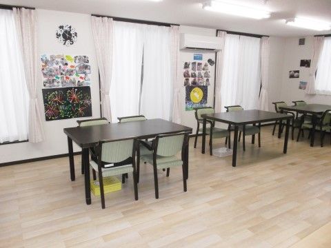 薄手のカーテンが閉められた窓が並んでいるフローリングの広間